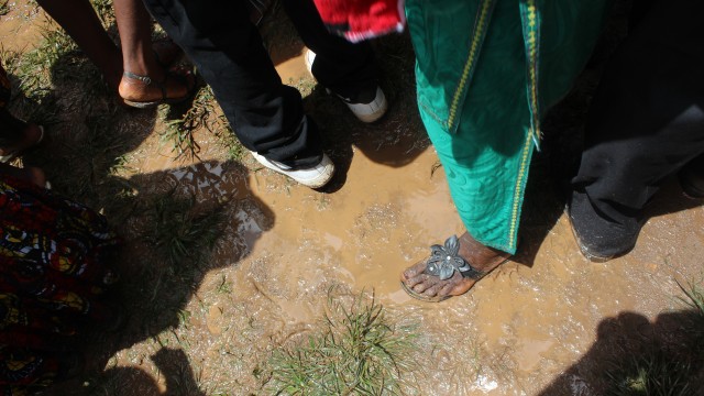 Guests stand on muddy ground. Photo: Jefferson Krua