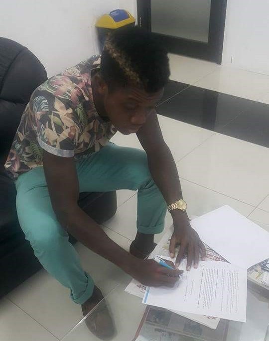 Keith Nah signs the contract extension. Photo courtesy of Keith Nah